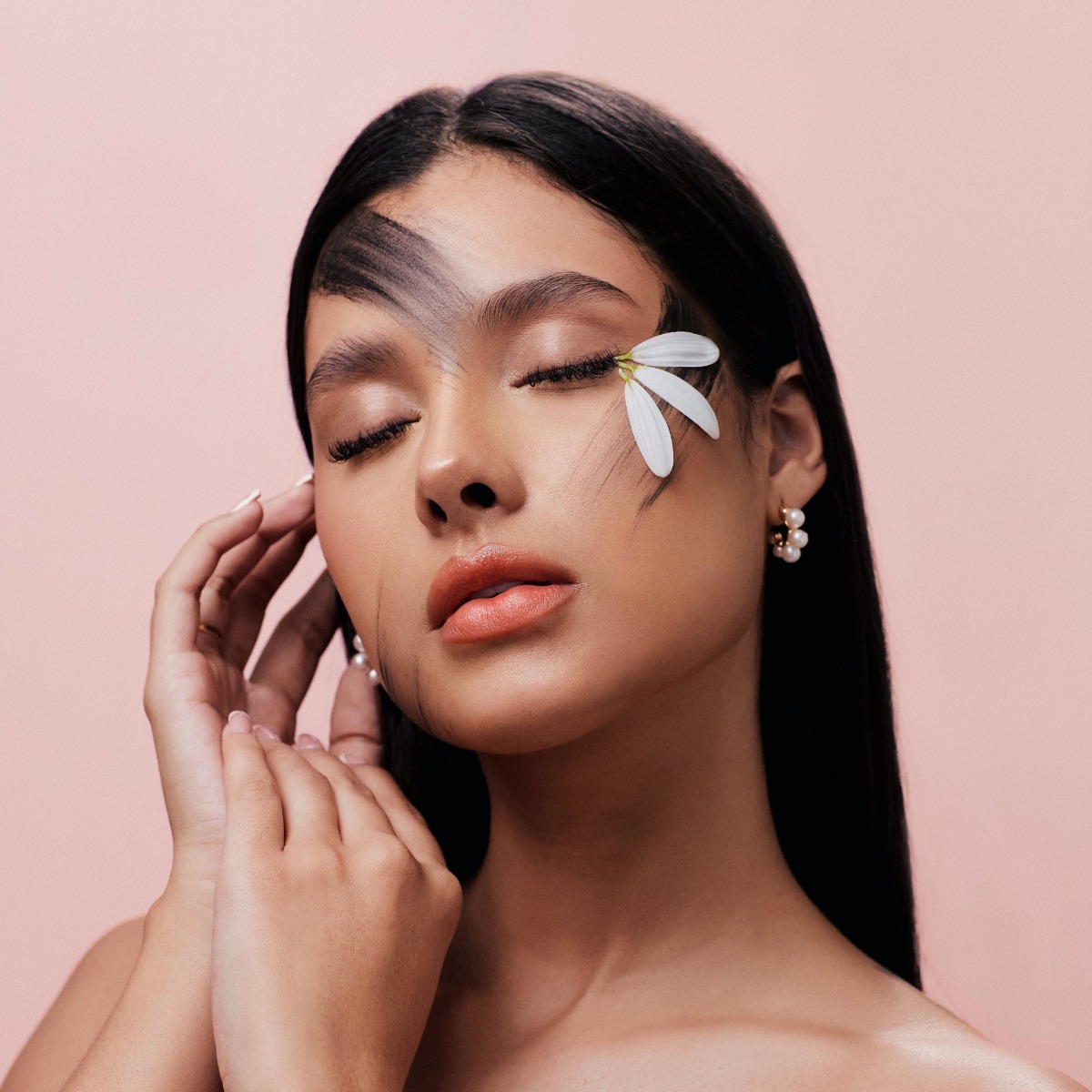woman posing with makeup and a flower on her face