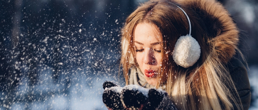 Woman blowing snow in the winter